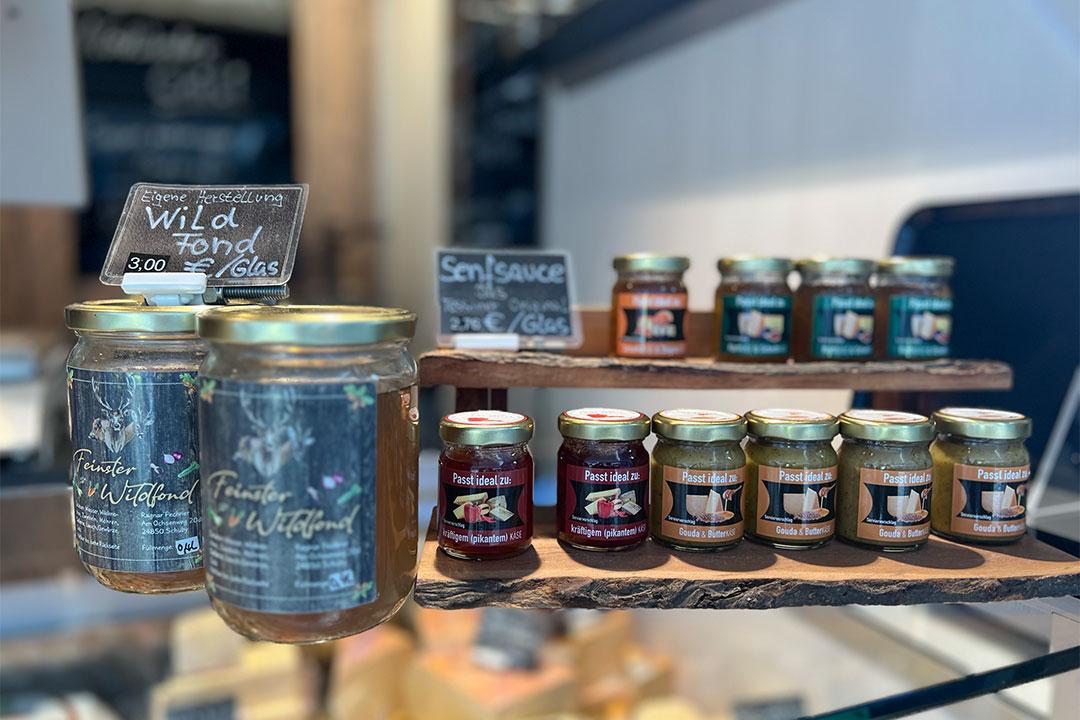 Nahansicht auf die Auslage eines Standes auf dem Rendsburger Wochenmarkt mit Wildfonds und verschiedenen Saucen im Glas