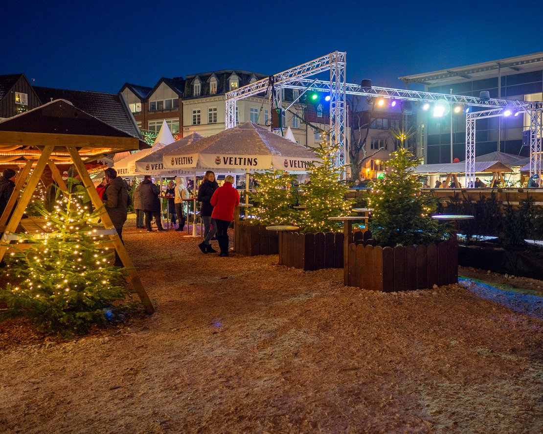 Blick auf den Rendsburger Weihnachtsmarkt mit Tannenbäumen und der Eisbahn