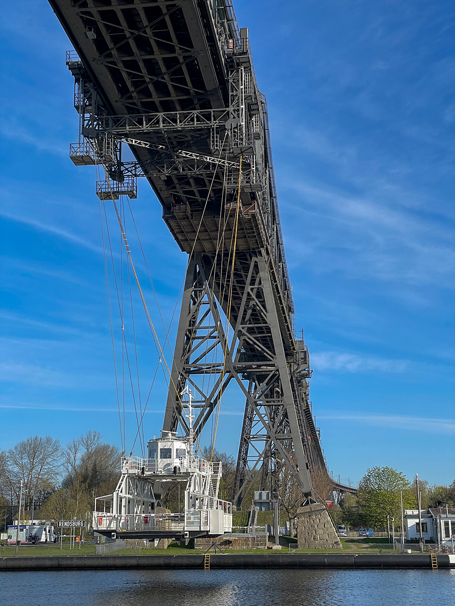 Die Schwebefähre verkehrt unterhalb der Eisenbahnhochbrücke über den Nord-Ostsee-Kanal.